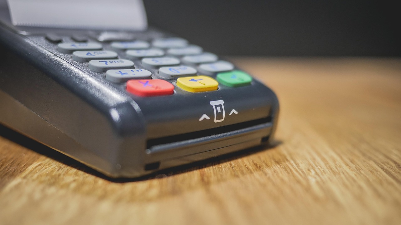 Immagine di un POS con grafico delle nuove commissioni per i commercianti.