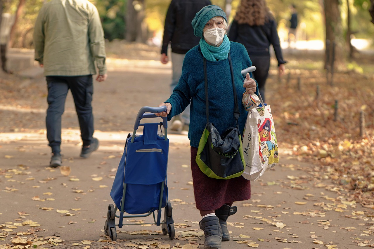 Pensionati sorridenti discutono di aumenti pensionistici in un caffè.