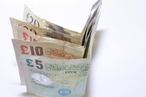 Due mani che si separano, con banconote e monete sul tavolo, simboleggiando un conto cointestato in fase di divisione.